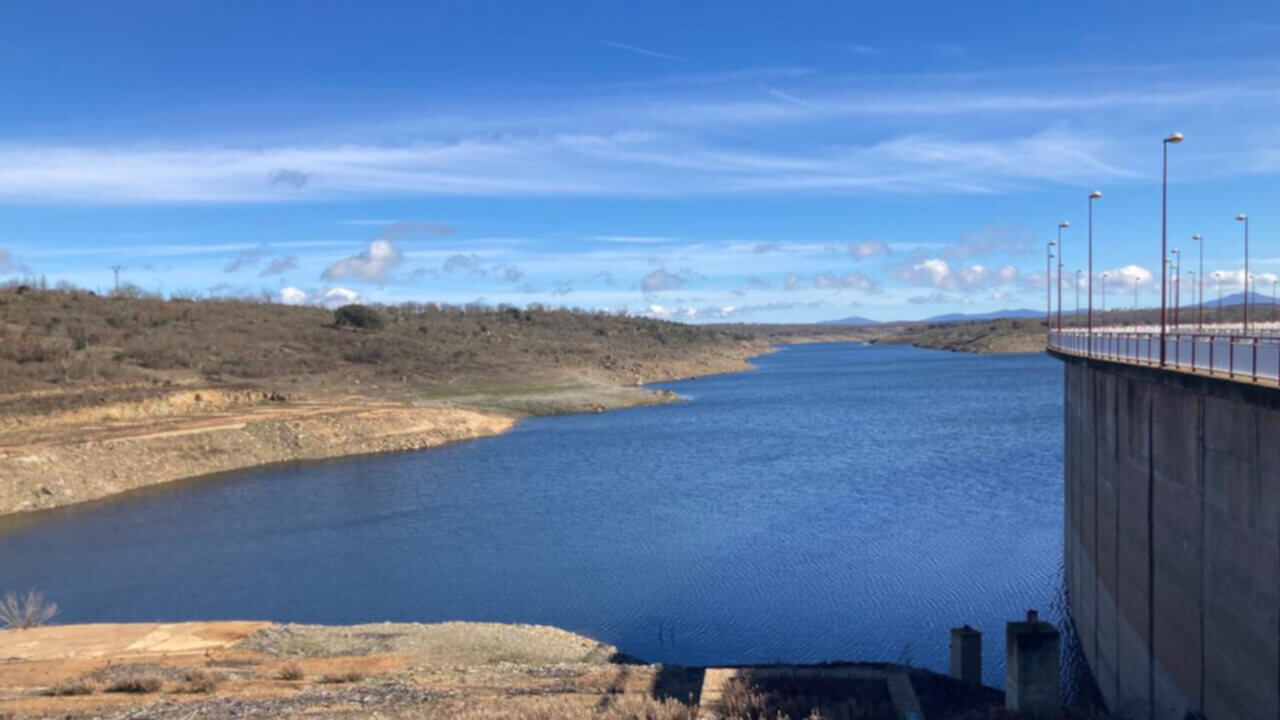 Vista aérea de un embalse español con niveles de agua notoriamente reducidos